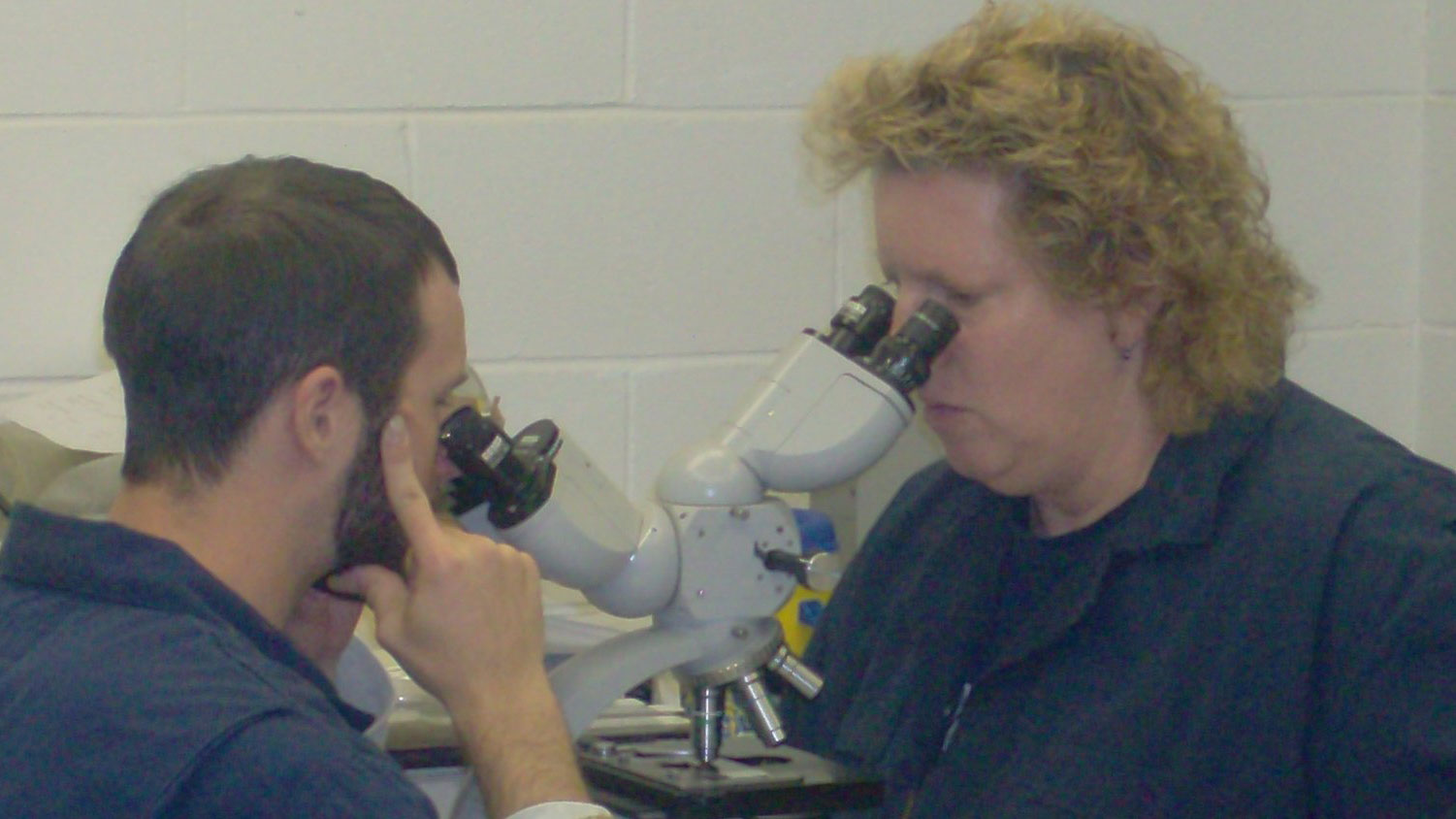 Student and teacher looking in a microscope.